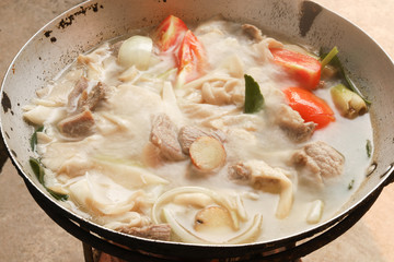 Boiled pork with mushrooms, kaffir lime leaves in a pan.