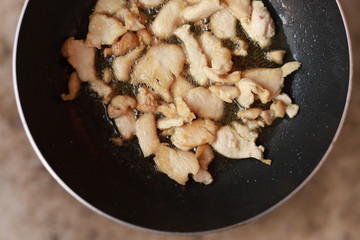 Oil fried pork in a frying pan.