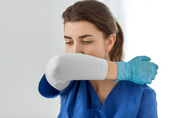 medicine, healthcare and people concept - doctor or nurse in gloves coughing covering mouth with...
