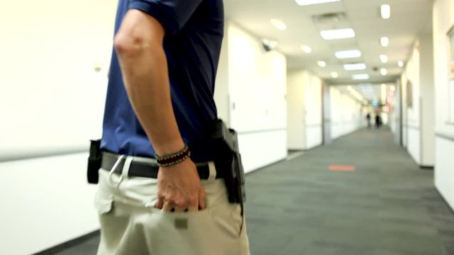 A security officer stopping to check location of the intruder on his cellphone - close up