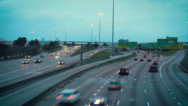 Time Lapse of the city of Houston busy traffic at sunset. Rush hour on the Interstate Freeway in Houston Texas. Intersection of I45 and I610. Wide Shot, day to night TimeLapse, Wide Shot