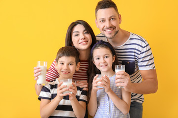 Obraz premium Family drinking milk on color background
