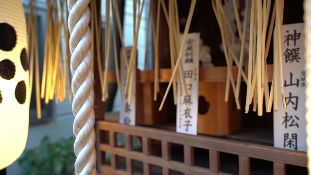 Closeup View Of A White Rope And Japanese Lanterns Hanging Outside The Small Shrine In Japan - Slow Motion Sliding Shot