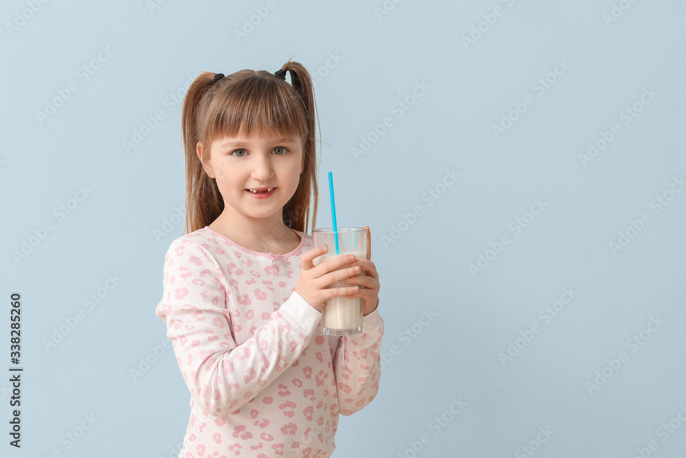 Wall mural Little girl with glass of milk on grey background