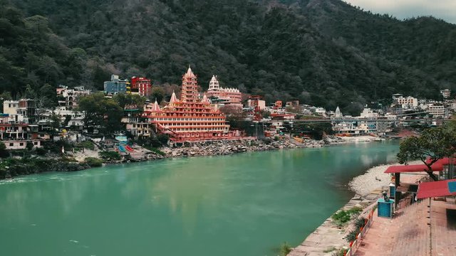 Drone shot, Aerial View, Lakshman Jhula bridge and Tera Manzil Temple, Trimbakeshwar in Rishikesh, Ganges River, holy town and travel destination in India. 