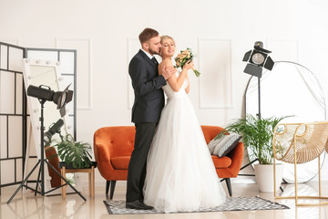 Young wedding couple posing for photographer in studio
