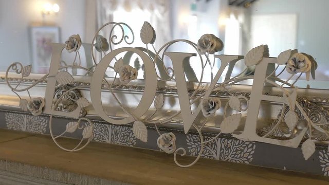 A White Letter Standees Of Love With Rose Flowers And Leaves As A Part Of Wedding Design. -close up shot
