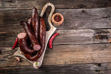 Smoked sausage on a wooden rustic table, natural product from organic farm, produced by traditional methods. menu banner space for text