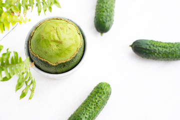 peeled on top of a ripe fresh avocado with a fleshy pulp and cucumber. Green concept. Flat lay.
