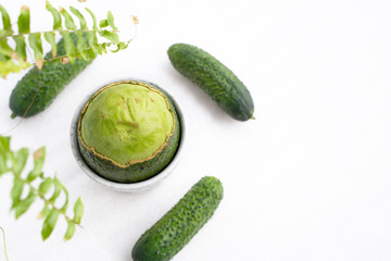 peeled on top of a ripe fresh avocado with a fleshy pulp and cucumber. Green concept. Flat lay.
