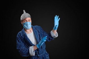 scared man in foil cap, holey bathrobe, gloves and medical mask