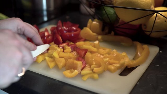 Close-up on hands which sliceing colour pappers on plastic board