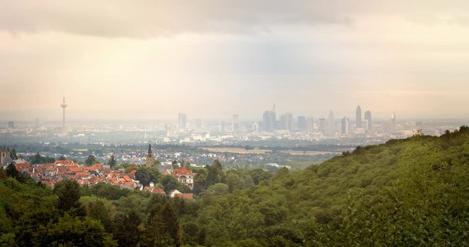A historical German town in front of Frankfurt&acute;s modern skyline. Warm overcast sky, viewed from the Taunus hills.
