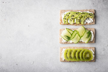 Different kinds of vegetarian sandwiches on a light background. Top view, place for text.