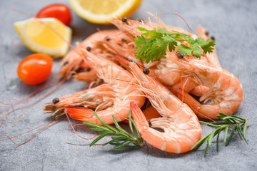 fresh shrimp on dark plate with ingredients herb and spices - cooking seafood shrimps prawns served on a table background