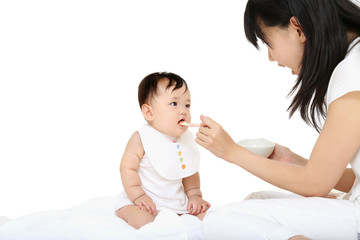 Obraz na płótnie Canvas 赤ちゃんに離乳食を食べさせる若い母