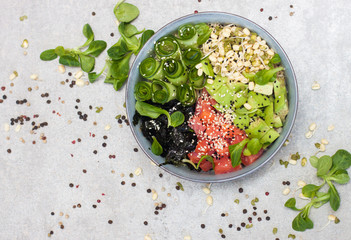 Poke bowl with smoked salmon, cucumber, avocado, sea kale, bean sprouts, sesame and herbs. Grey...