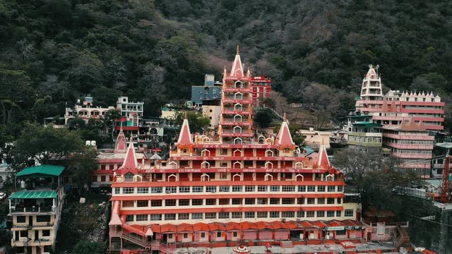 Drone shot, Aerial View, Lakshman Jhula bridge and Tera Manzil Temple, Trimbakeshwar in Rishikesh, Ganges River, holy town and travel destination in India. 