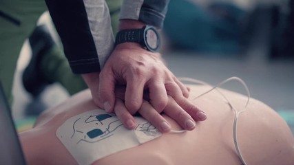 Emergency training instructor, perfoming cpr on emergency test doll.