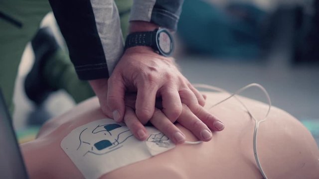 Emergency training instructor, perfoming cpr on emergency test doll.
