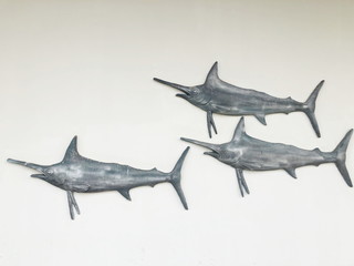 Stucco Gray fish statue decorated on the wall.