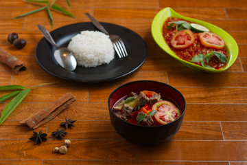 indonesian beef stew on a black bowl over wooden background. traditional meat soup.