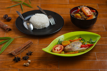 traditional indonesian tilapia soup on a green plate over wooden background.