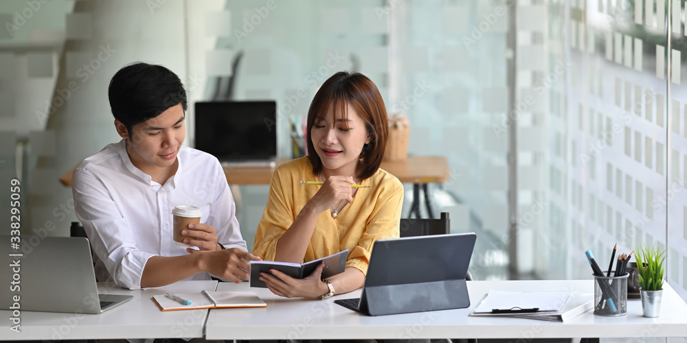 Poster photo of business consulting team working together with computer tablet while sitting at the long wo