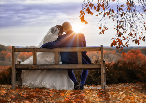 Wedding couple on a bench at sunset