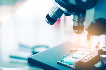 Close up of examining of test sample under the microscope in laboratory.
