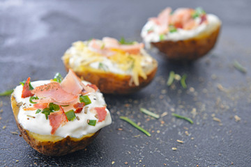 Tasty baked potato with sour cream on dark background