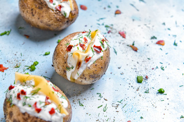 Tasty baked potato with sour cream on color background