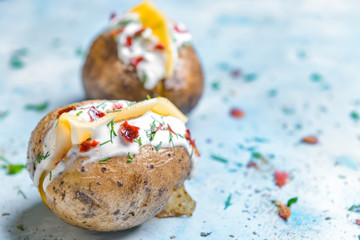 Tasty baked potato with sour cream on color background