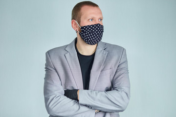 Portrait of man wearing black mask at grey background.
