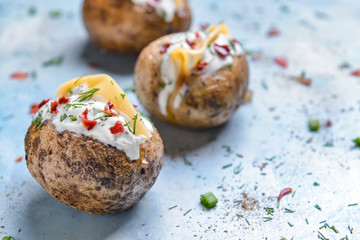 Tasty baked potato with sour cream on color background