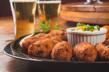 Comida de boteco brasileira bolinho de bacalhau peixe servido em tigela em balcão de boteco