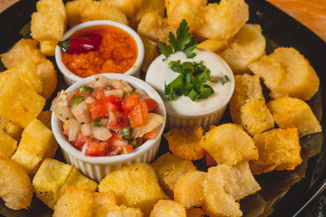 Comida de boteco brasileira mandioca frita servida em tigela em balcão de boteco