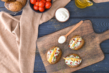 Tasty baked potato with sour cream on table