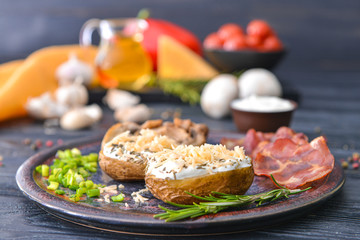 Tasty baked potato with sour cream, mushrooms and bacon on table