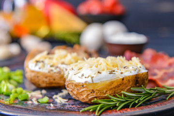Tasty baked potato with sour cream, and cheese on plate, closeup