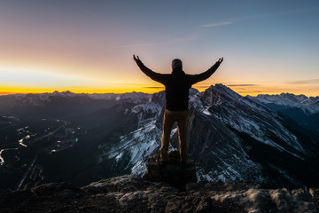 Man posing on top of the mountain during the sunrise. EEOR, Canmore, Canada