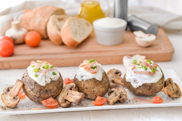 Tasty baked potato with sour cream and mushrooms on plate