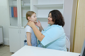 Fototapeta premium The girl came to the pediatrician for an examination. the doctor conducts an external examination and diagnosis of the patient at a reception in the office