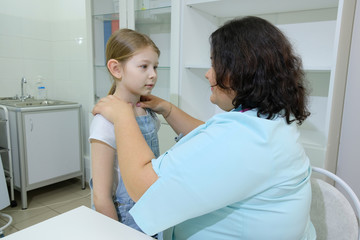 The girl came to the pediatrician for an examination. the doctor conducts an external examination and diagnosis of the patient at a reception in the office