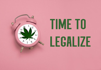 pink alarm clock with a leaf of cannabis and the inscription time for legalize on a pink...