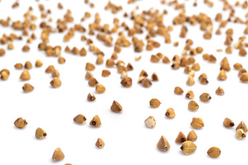 Buckwheat grain organic raw seeds isolated on white. Brown vegetarian cereal food background. Healthy eating, dieting and detoxication concept, space for text.