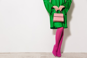 Young glamour girl in green dress with pink bag.