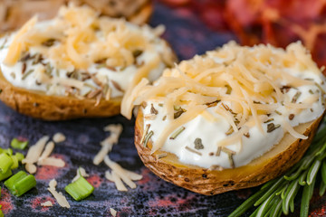 Tasty baked potato with sour cream, and cheese on plate, closeup