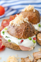 Fototapeta na wymiar Tasty baked potato with sour cream on plate, closeup