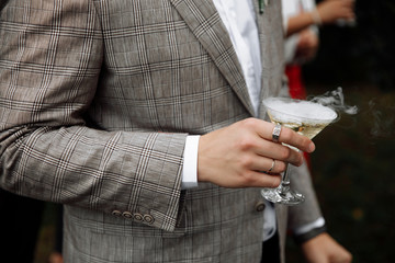 glass of champagne with a dry ice haze in hand